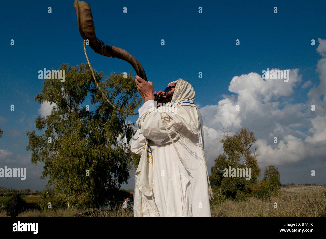 A religious Jew wrapped with traditional Talit shawl blows the Shofar