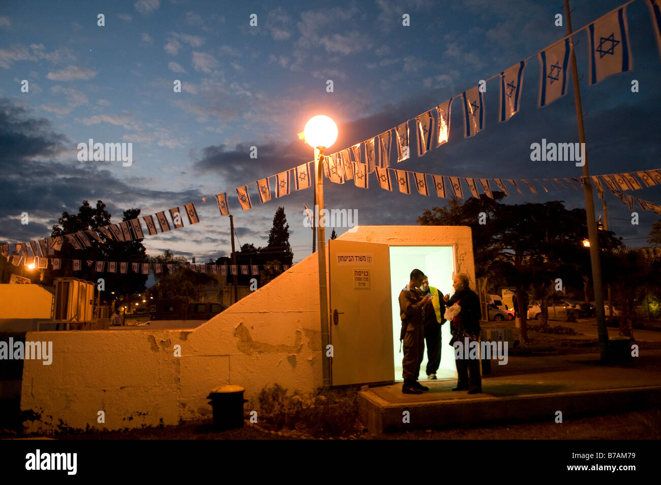 An Israeli soldier speaks to civilians at the entrance to a public bomb shelter in the southern city of Sderot, Israel Stock Photo