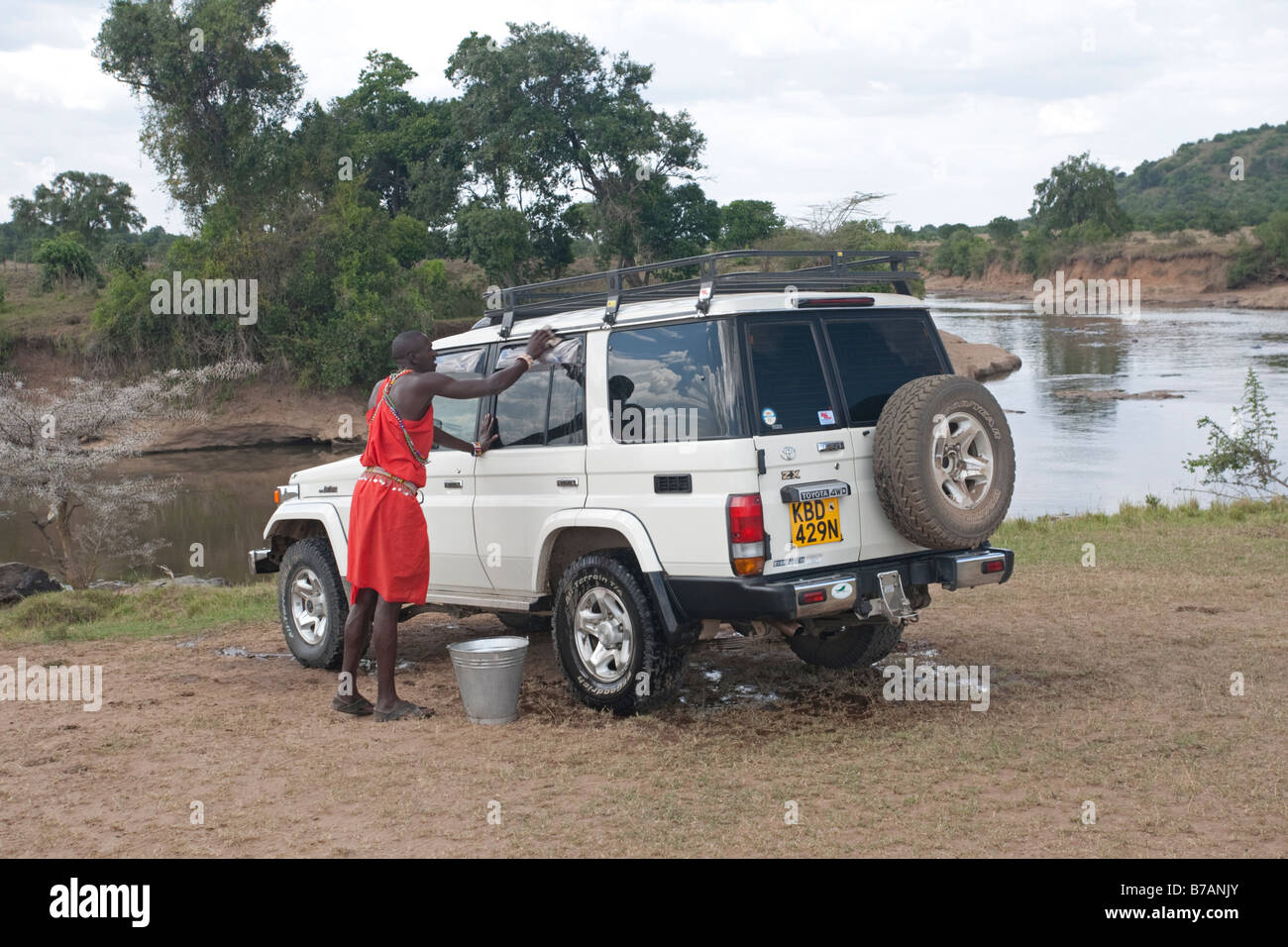 Masai washing Toyota Land Cruiser by Mara River Masai Reserve Kenya