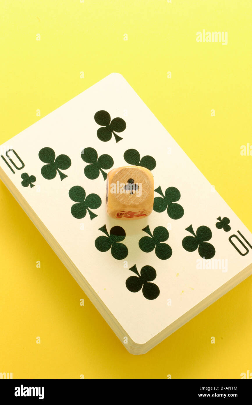 Club dice on pack of playing cards Stock Photo