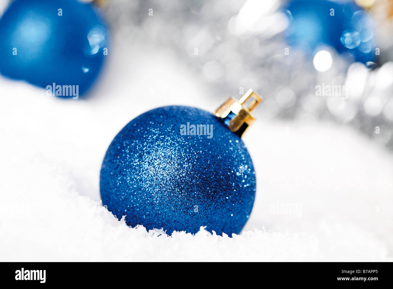 Blue glitter Christmas tree balls on snow with Christmas decorations Stock Photo