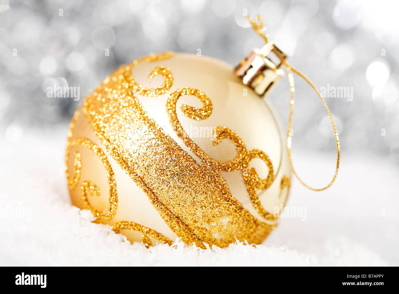 Gold glitter Christmas tree ball on snow with Christmas decorations