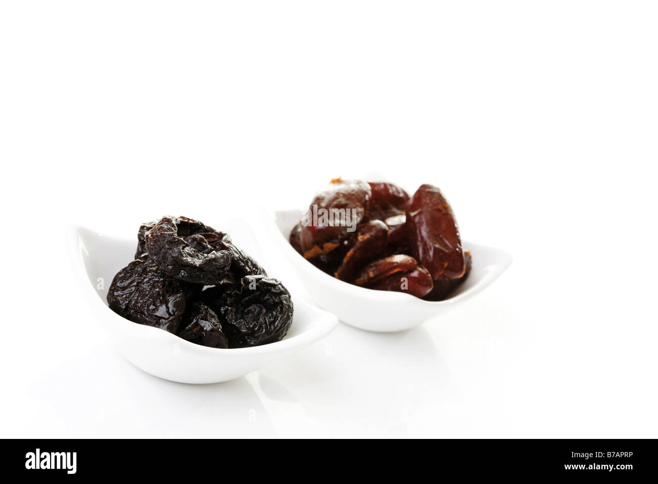 Dried prunes and dates in white bowls Stock Photo Alamy