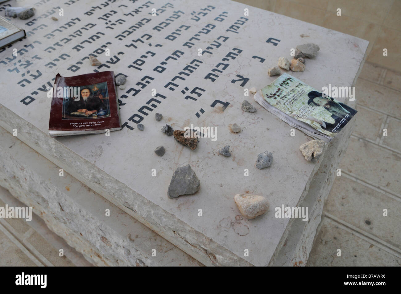 Prayer books and small pieces of stone over a tomb of a Sephardic Jew at  the cemetery in southern town of Netivot, Israel Stock Photo
