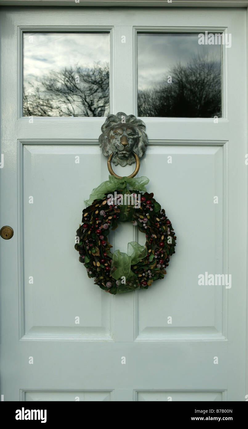 a front door decorated with a circular christmas decoration placed on