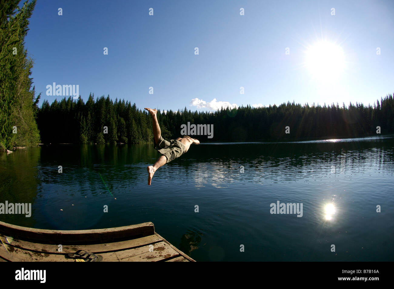 A swimmer dives into Cat Lake, a mountain lake, north of Squamish British Columbia, Canada Stock Photo