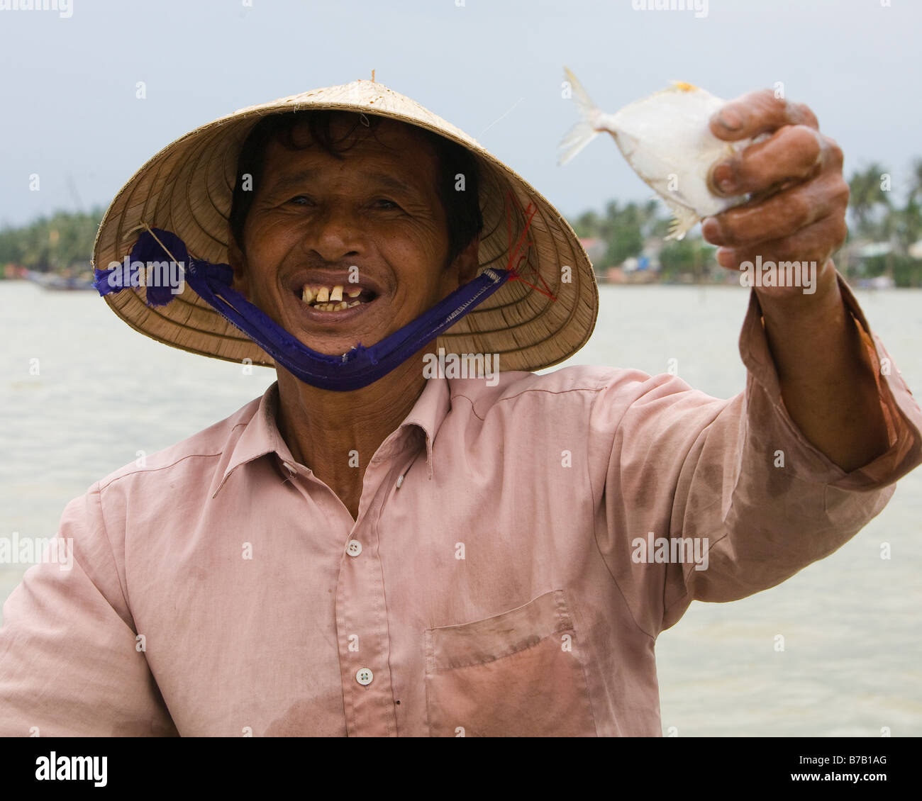 Vietnamese fisherman with fish he has caught Stock Photo Alamy