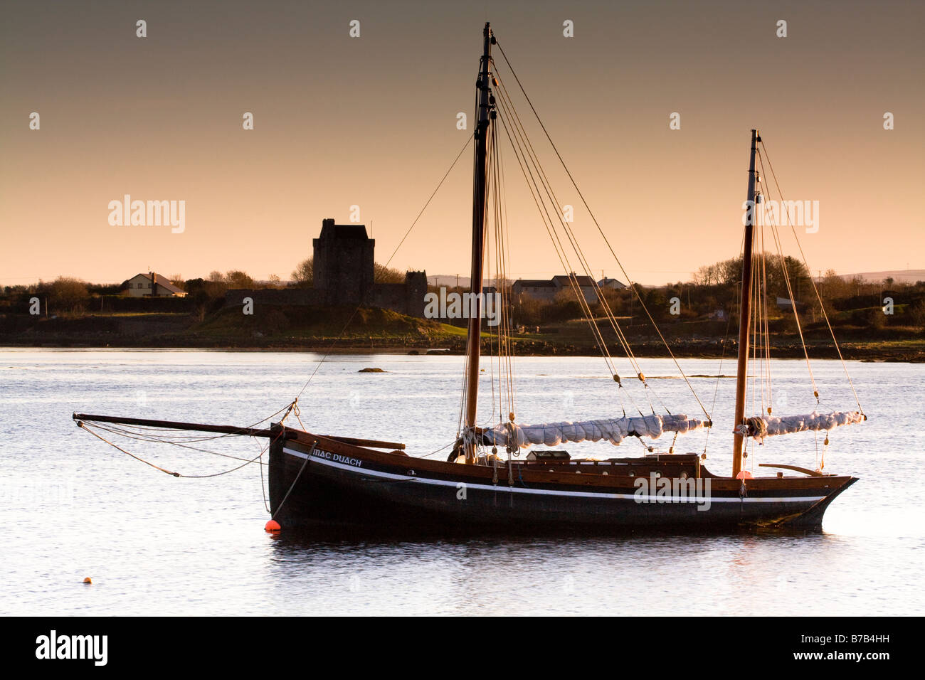 Galway hooker in kinvara with dunghaire castle in the background Stock Photo