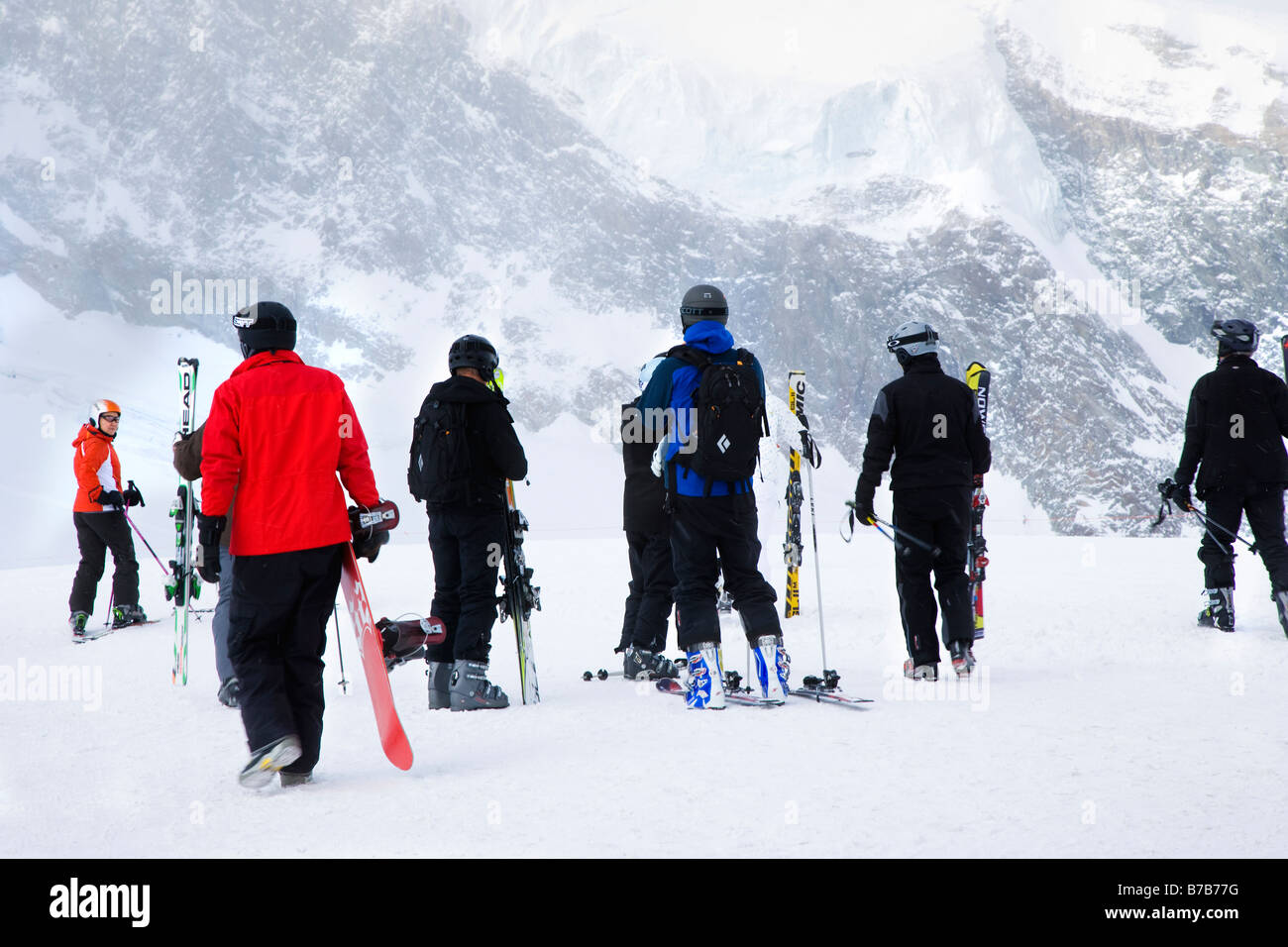 Skiers and snowboarders at Allalin top station preparing to ski and snowboard, Saas Fee Switzerland Stock Photo