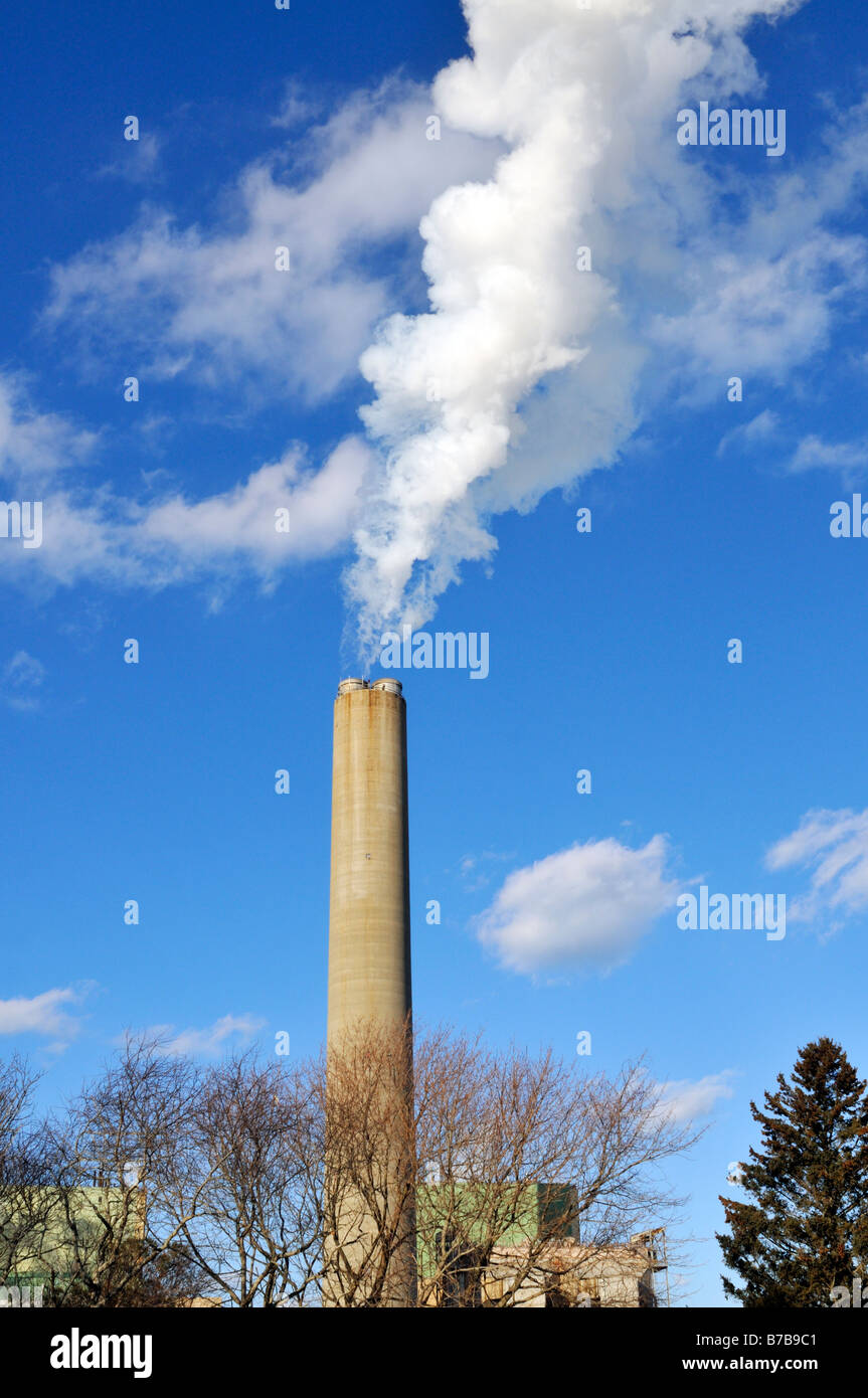 Power Plant smokestack from oil fired plant with exhaust against blue sky Stock Photo