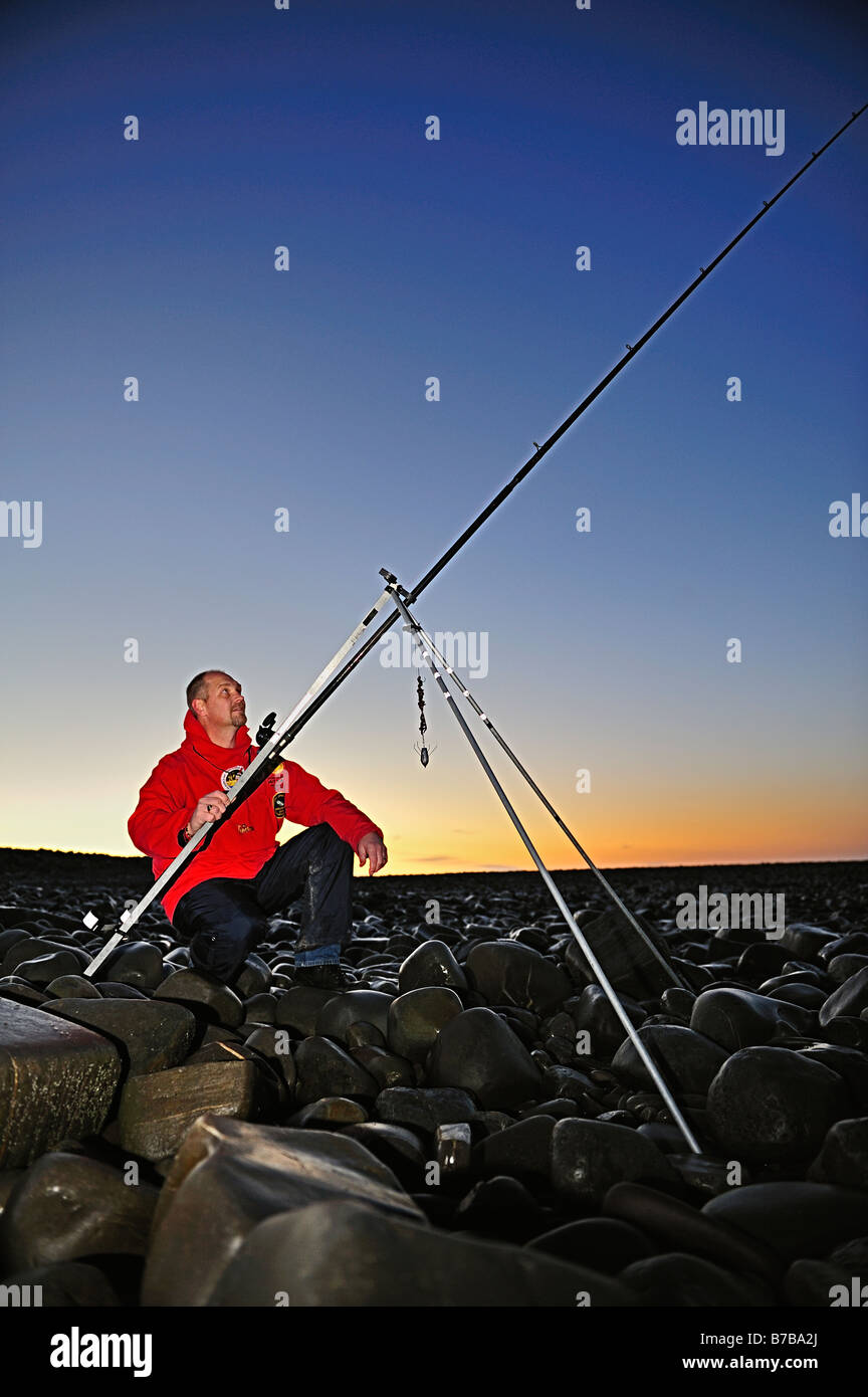Sea angler fishing at night. Stock Photo