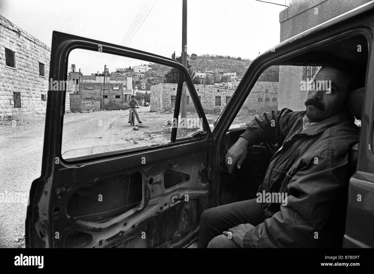 Palestinian villager sitting inside an abandoned car at the West Bank Israel Stock Photo