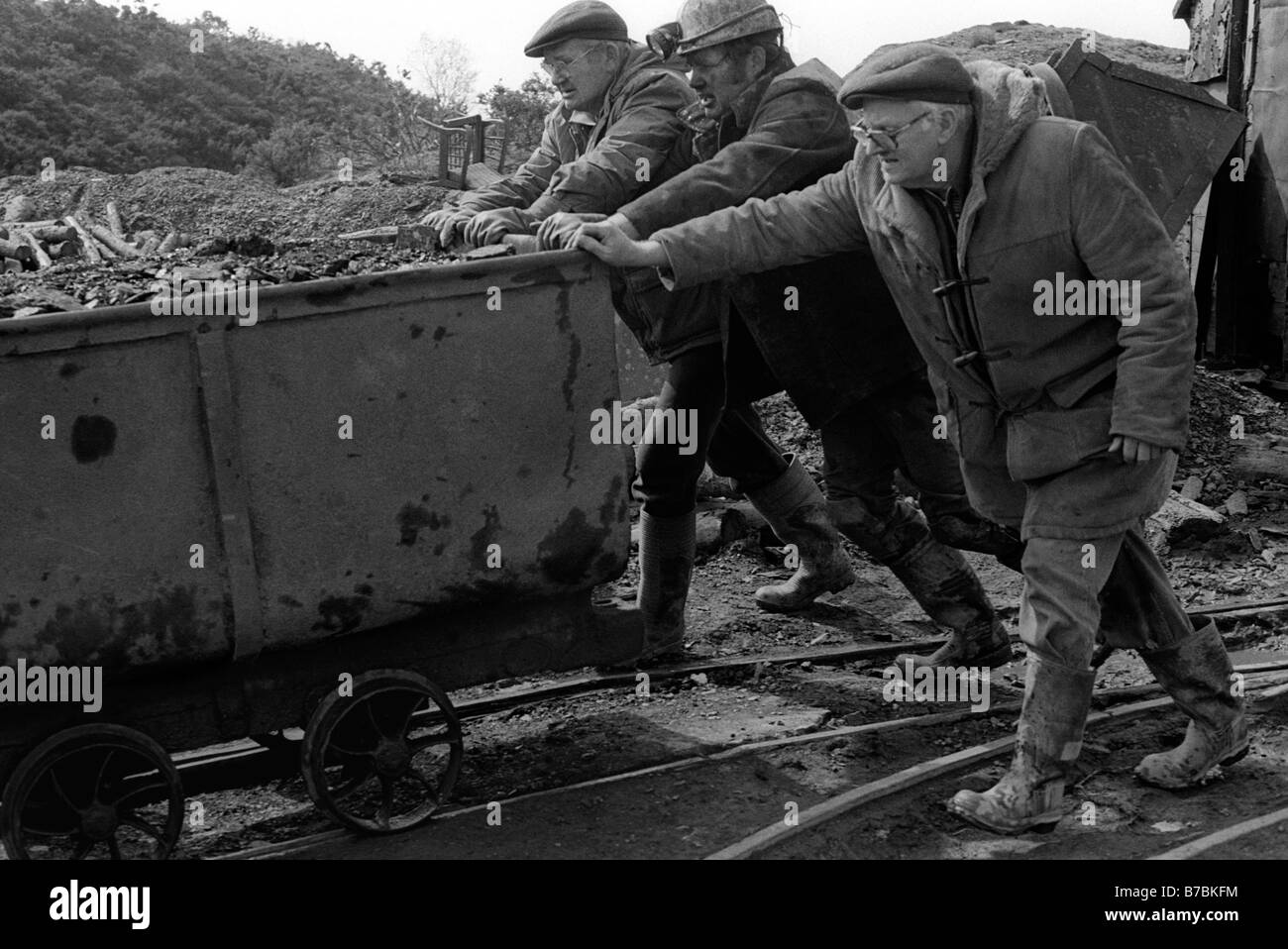 Miners pushing tram of coal on surface at Blaencuffin coal mine a privately owned drift mine above Pontypool South Wales UK Stock Photo