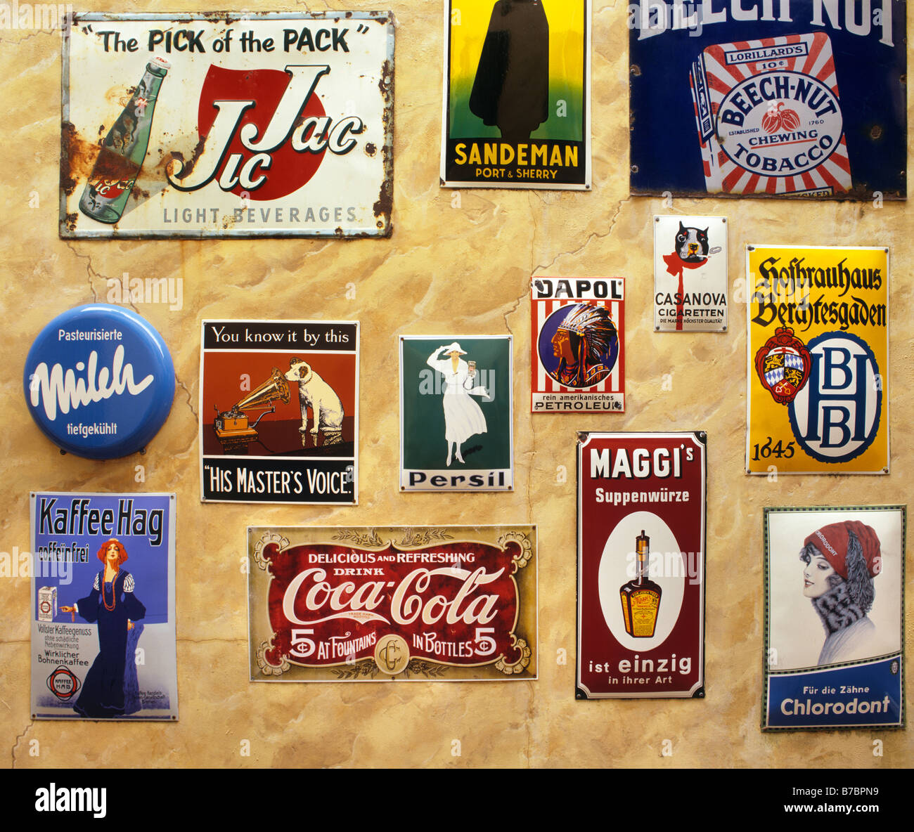 METAL PLAQUES used for advertising for products like RCA VICTOR and COCA COLA are displayed on a wall Stock Photo