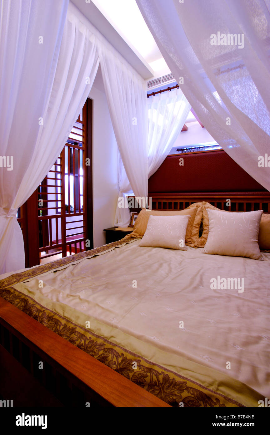 Luxurious Four Poster Bed With White Curtains Tied Up At The