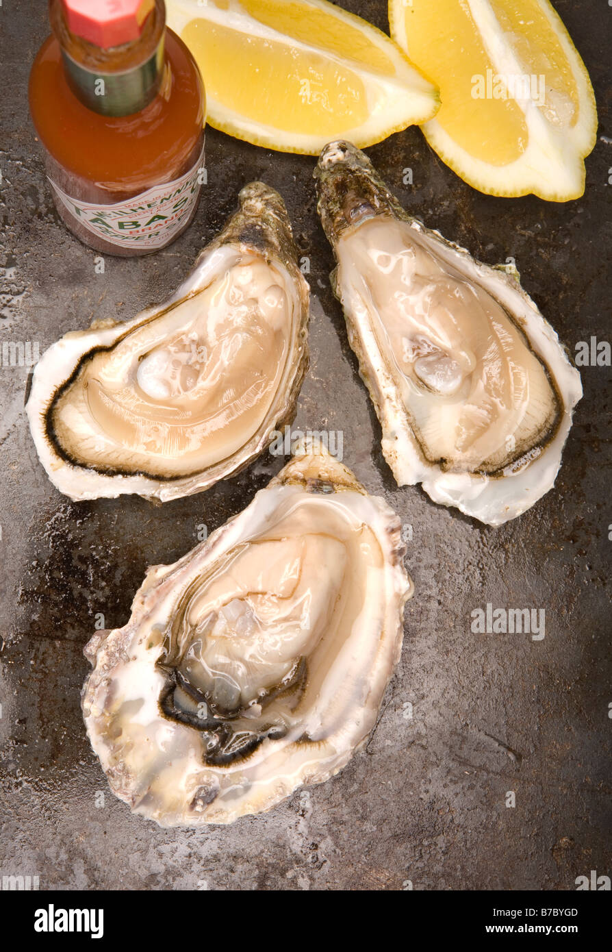 3 fresh oysters opened lemon and tabasco Stock Photo