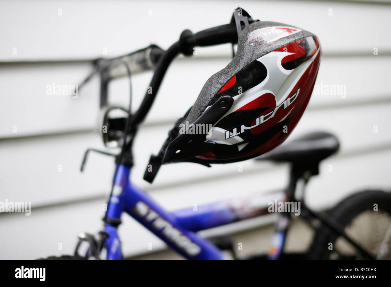 Boy's bike helmet hangs from handlebar Stock Photo