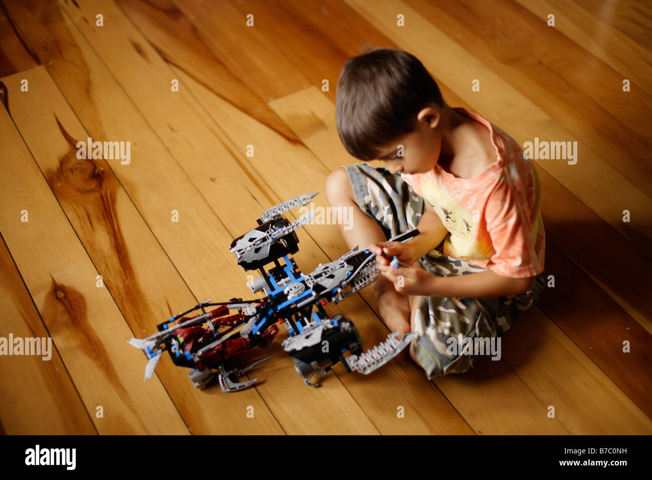 Six year old boy plays with lego bionicle spaceship toy Stock Photo