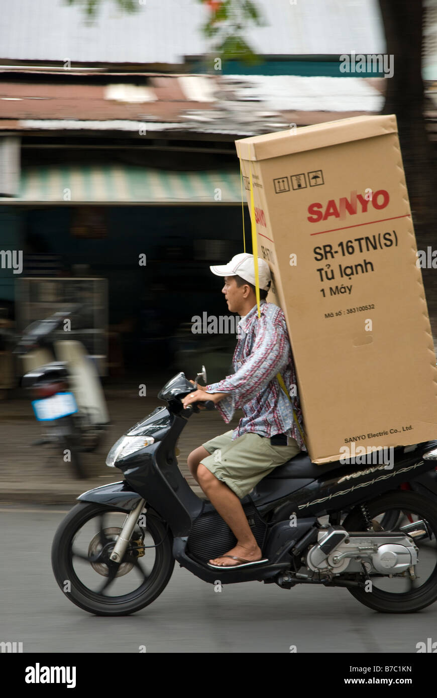 Vietnamese Delivery Driver with a refrigerator on his back in Saigon