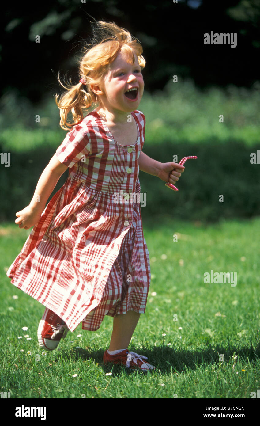 Red haired girl running in the park Stock Photo