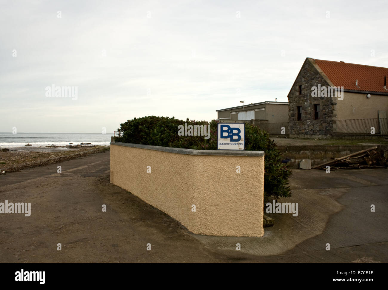 Small Bed and Breakfast sign on a wall by a road overlooking the Moray Firth in Scotland Stock Photo