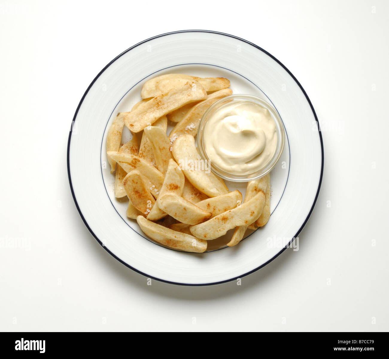Fried potato chips and dipping sauce on a round white dinner plate. Stock Photo