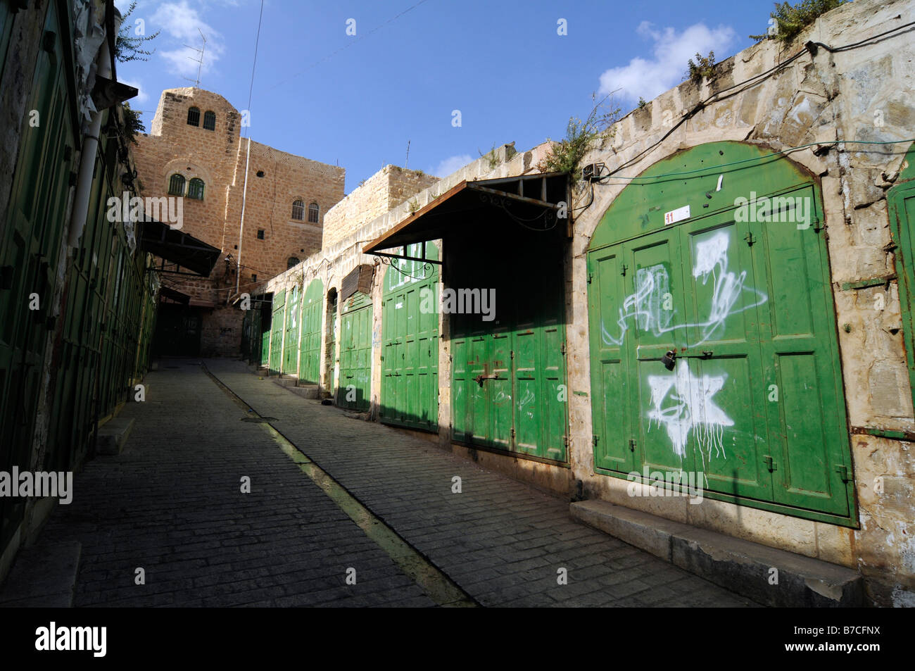 Street scene in Hebron under Israeli occupation: graffitis of David Star put by Jewish settlers on closed Arab shops. Stock Photo
