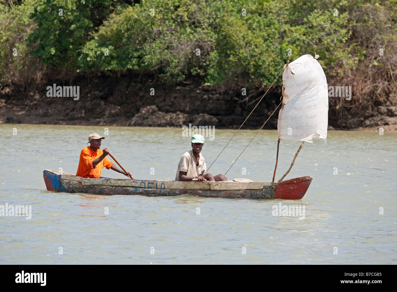 Two Africans sailing dugout canoe Mtwapa creek Mombasa Kenya Stock Photo