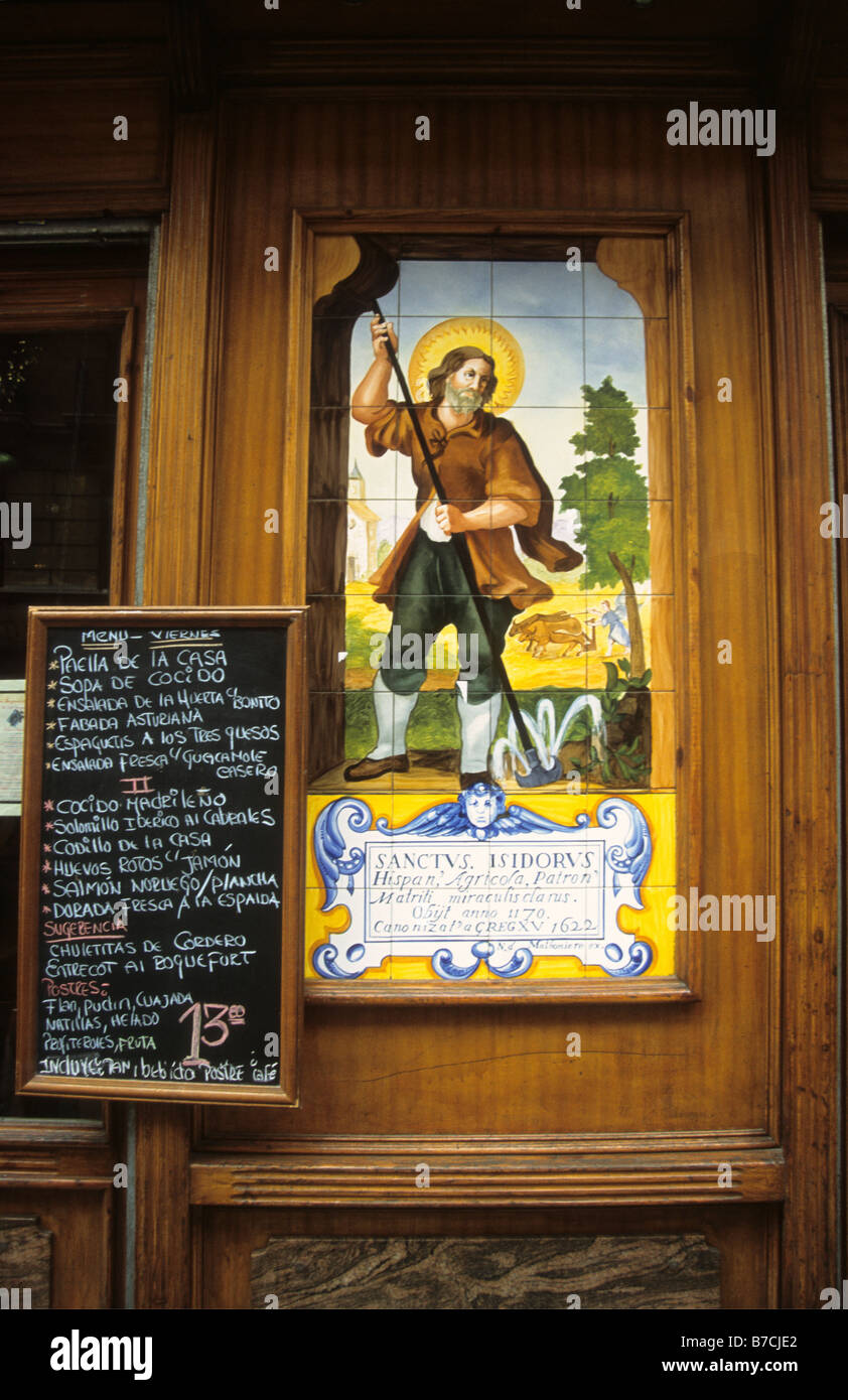 Painted ceramic tiles showing scene with Isidore the Laborer / San Isidro Labrador and lunch menu outside tapas bar, Madrid, Spain Stock Photo