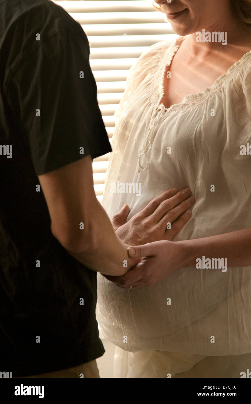 husband touching pregnant woman s stomach Stock Photo