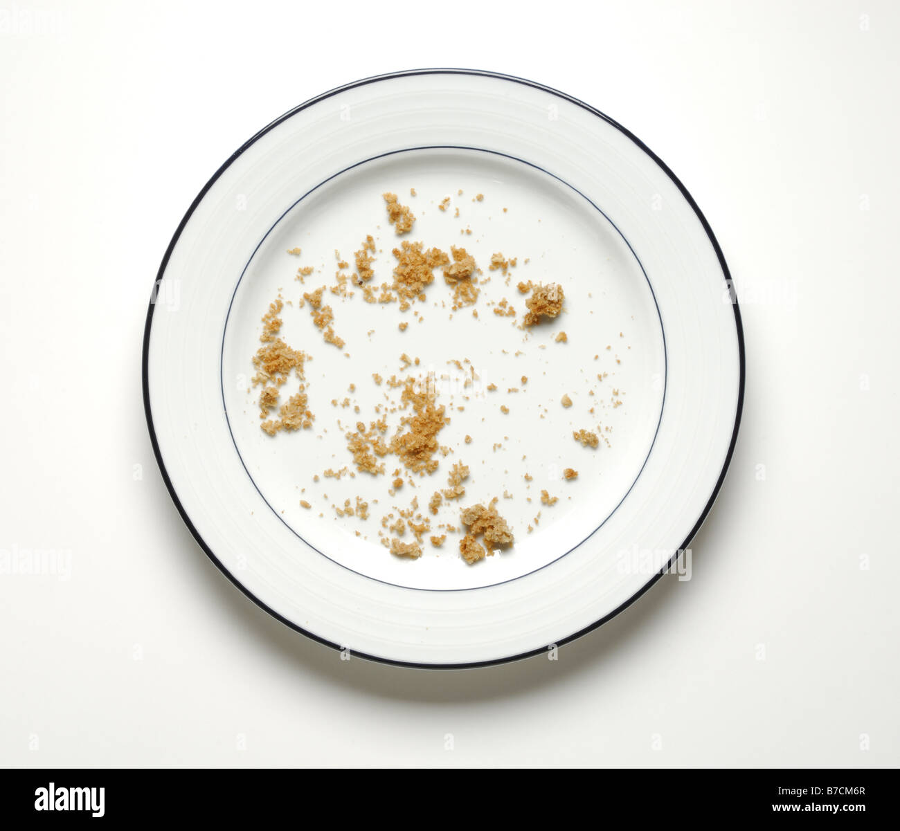 Crumbs of food on a round dinner plate Stock Photo