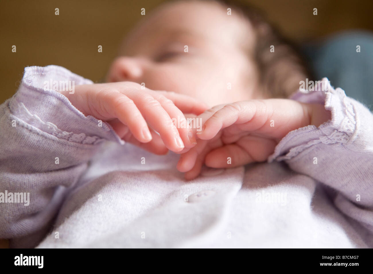 A baby girl sleeps with her hands across her chest Stock Photo Alamy