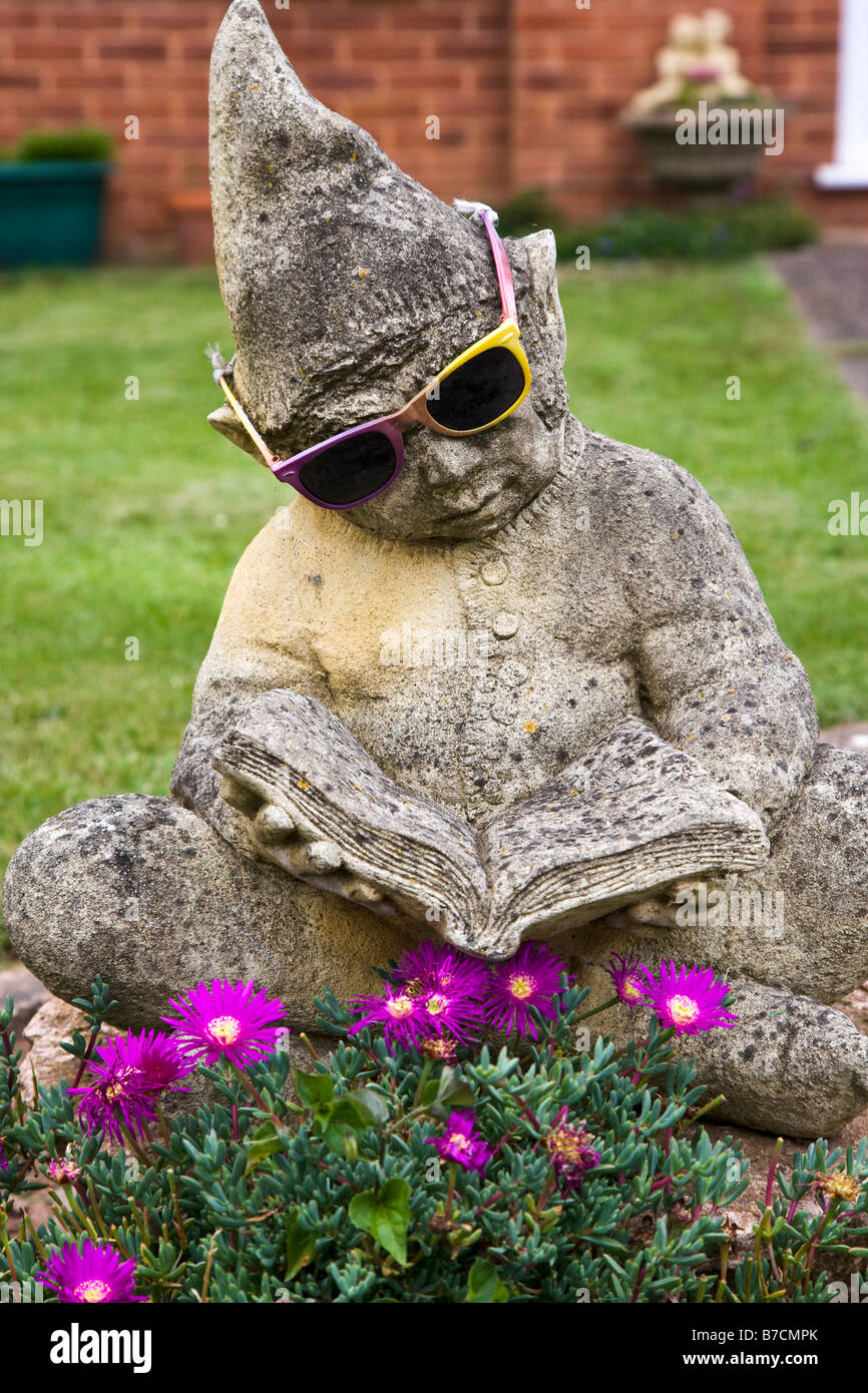 Gnome statue with sunglasses reading a book Stock Photo Alamy