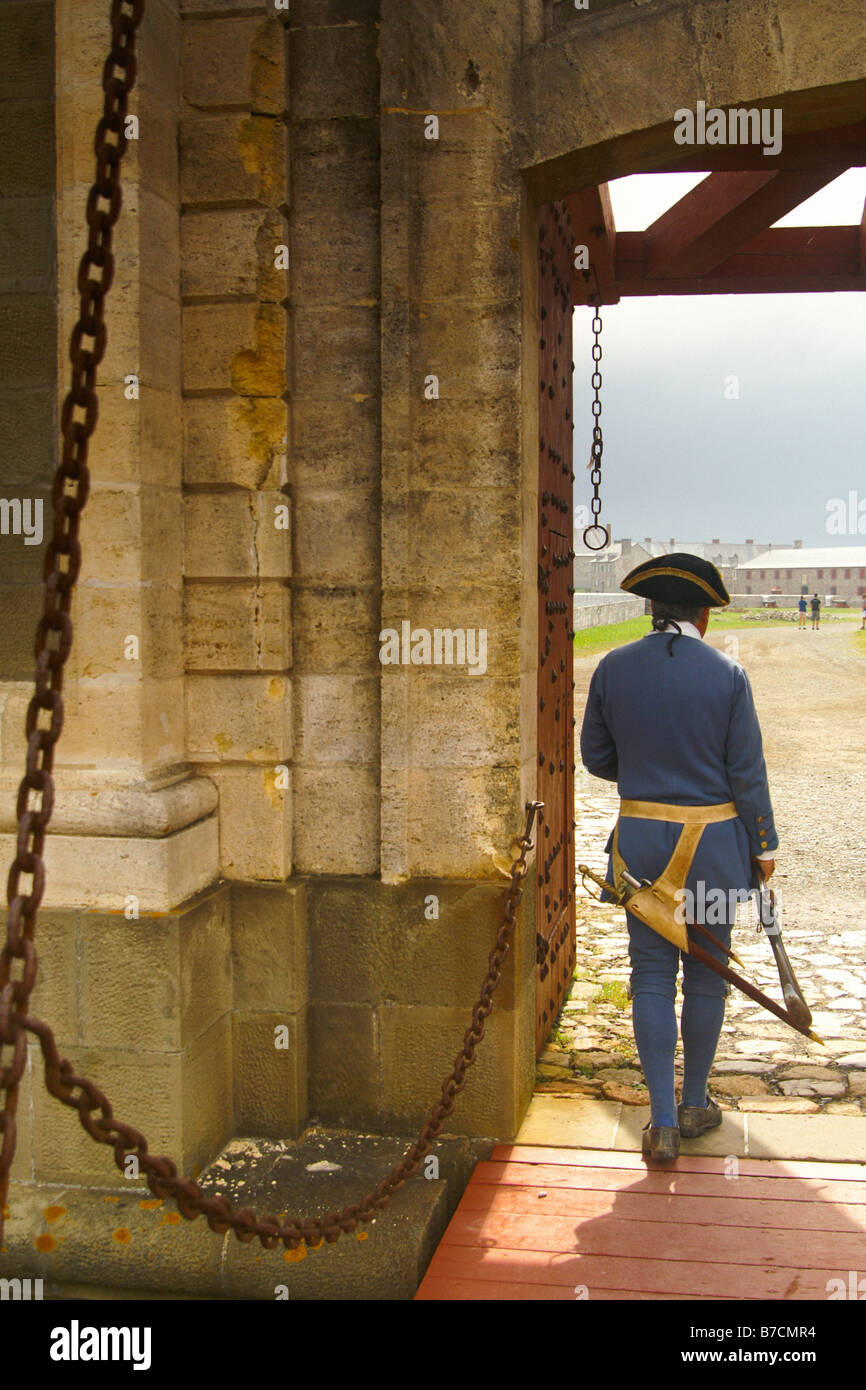 An actor in period dress stands guard over the main gate entering the Fortress of Louisbourg, Cape Breton, Nova Scotia. Stock Photo