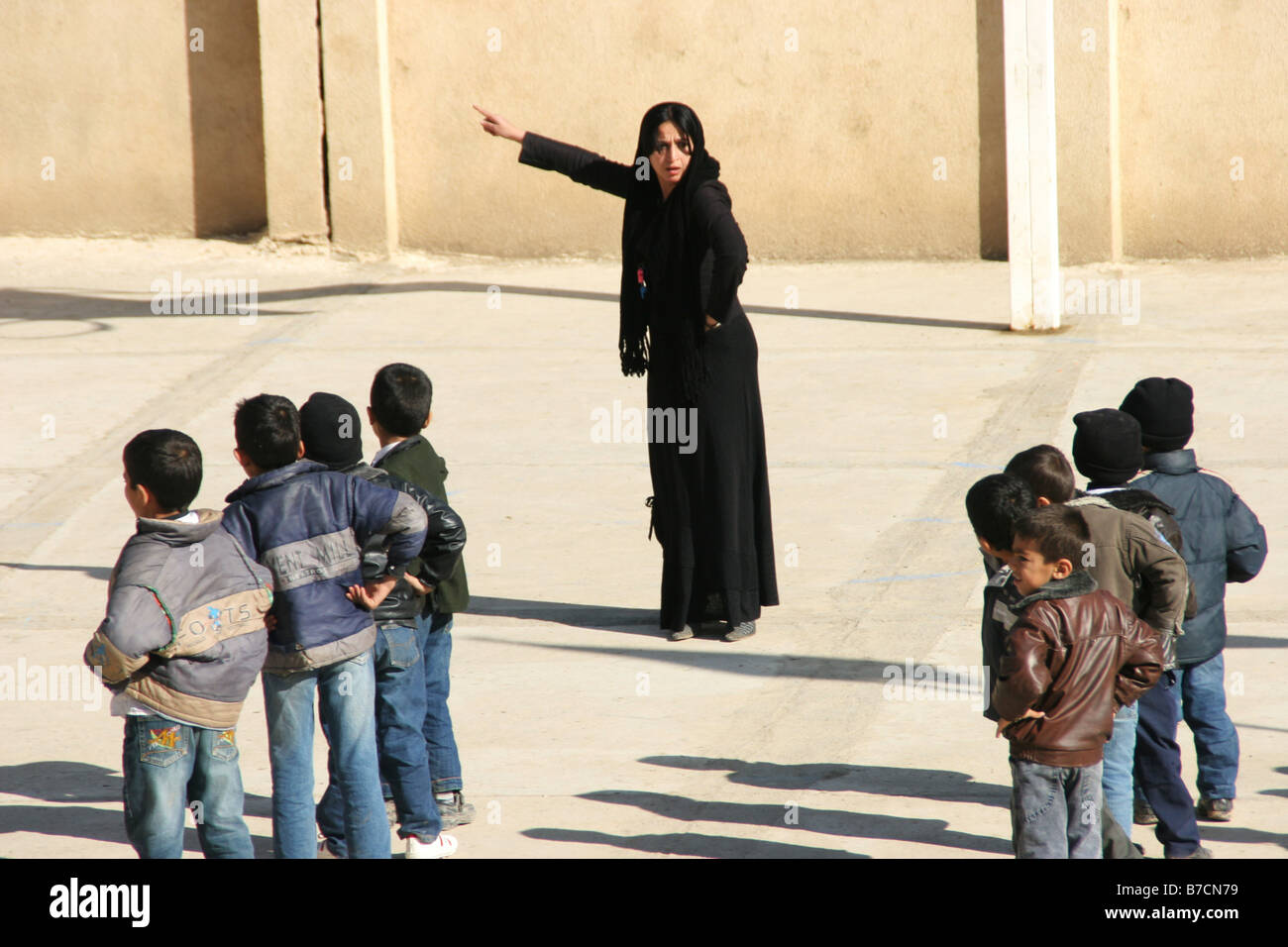 Muslim teacher in black and veiled with Kurdish students in a small  village school nearby Amedi, Iraq, Iraqi Kurdistan, Dahuk, Stock Photo