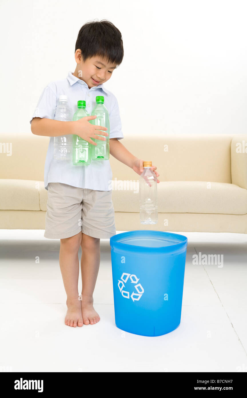 Little boy putting bottles into bottle bank Stock Photo Alamy