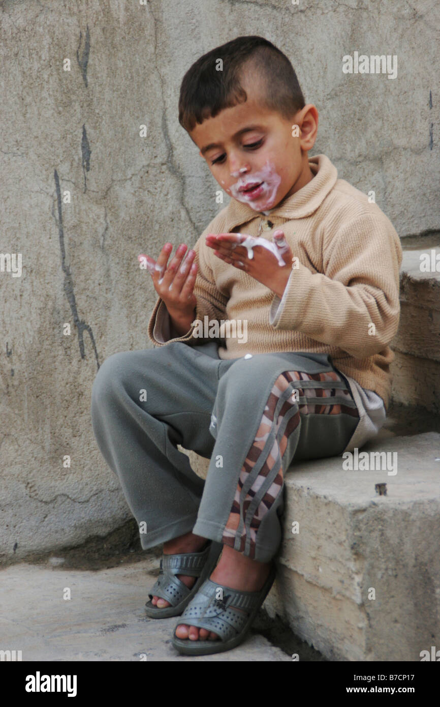 Kurdish boy eating ice cream and with dirty hands, Iraq, Iraqi Kurdistan, Sulaimaniyya, Sulaymaniyah Stock Photo