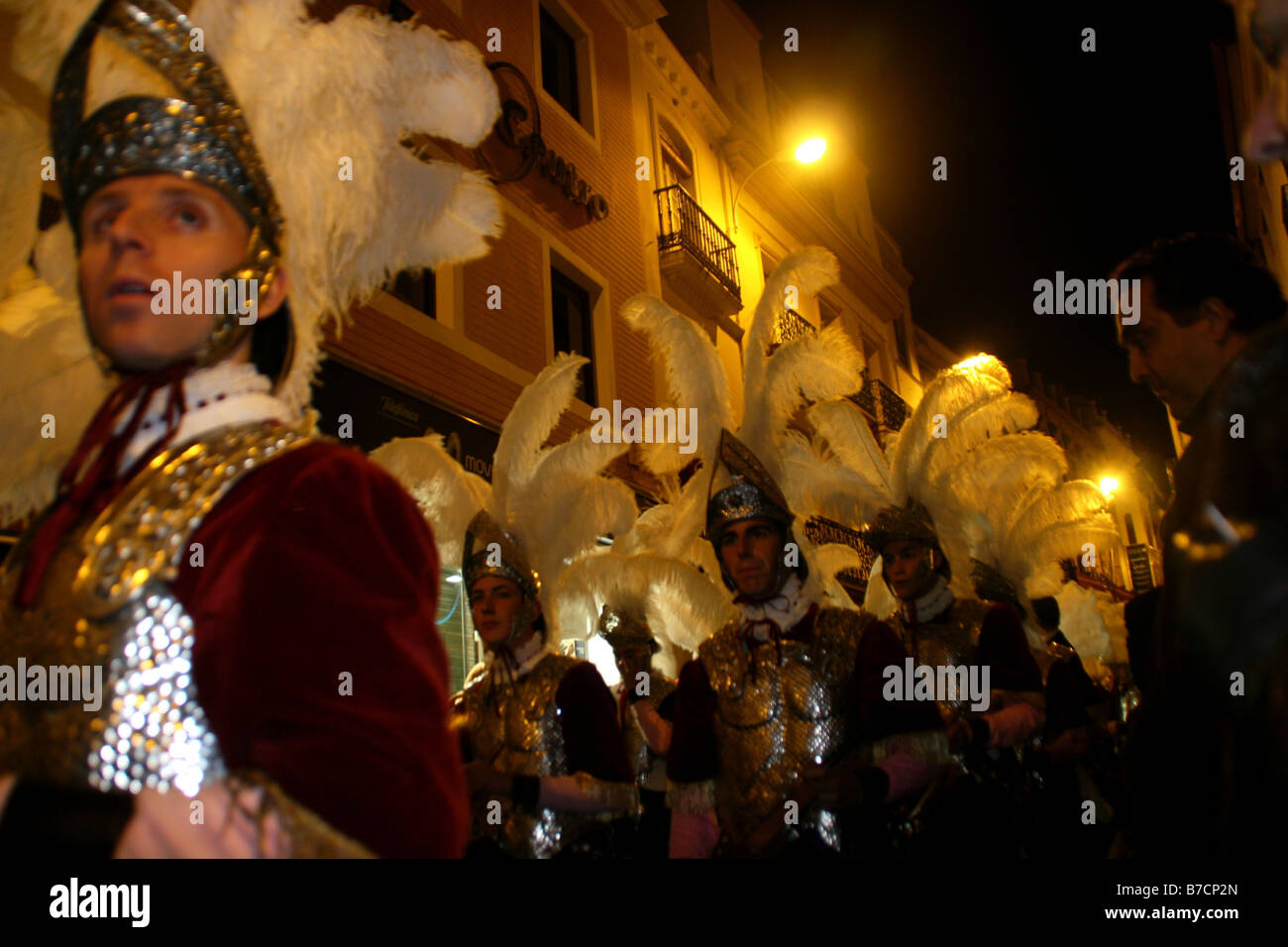Procession of a fraternity, Cofradia, during the Holy Week, in the night, dressed as Romans, with a helmet and feather jewelry, Stock Photo