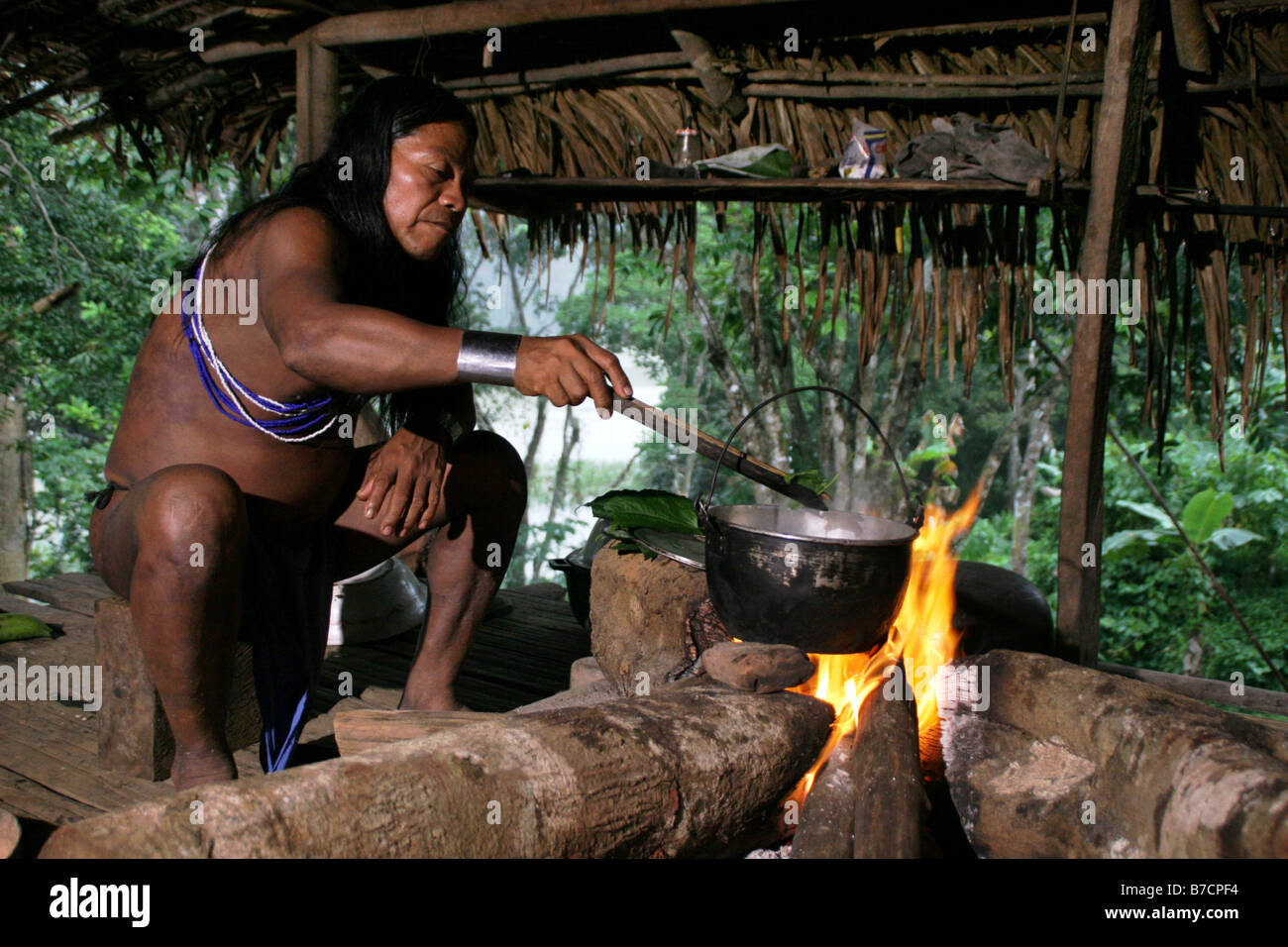 Shaman of the Embera Indians in traditional clothing in preparation for a potion in a small palm hut in the village Parar-Paru Stock Photo