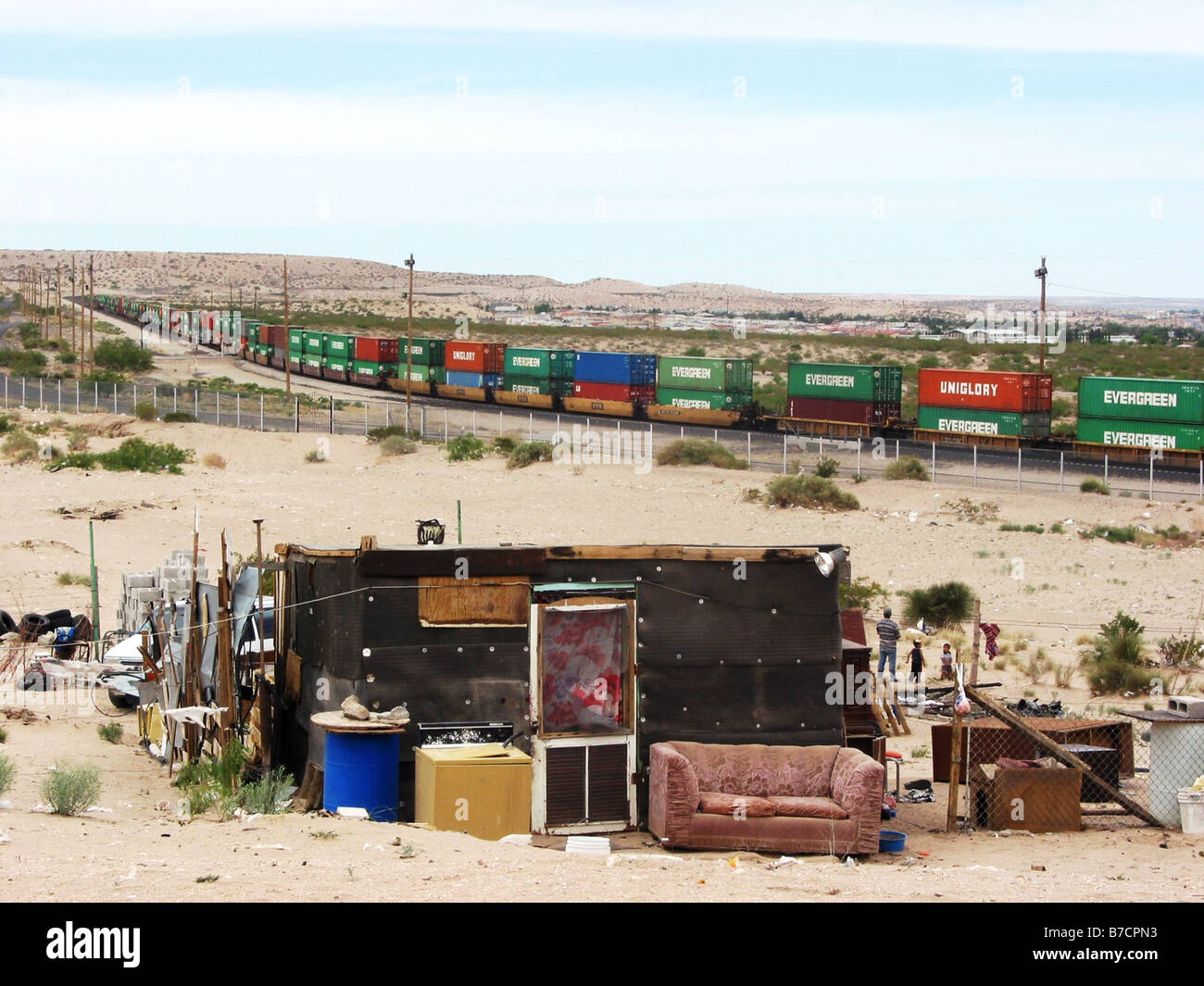 Poor dwelling in the northern border with Mexico to the United States and a long freight train passing, Mexico, Mexico, Chihuah Stock Photo