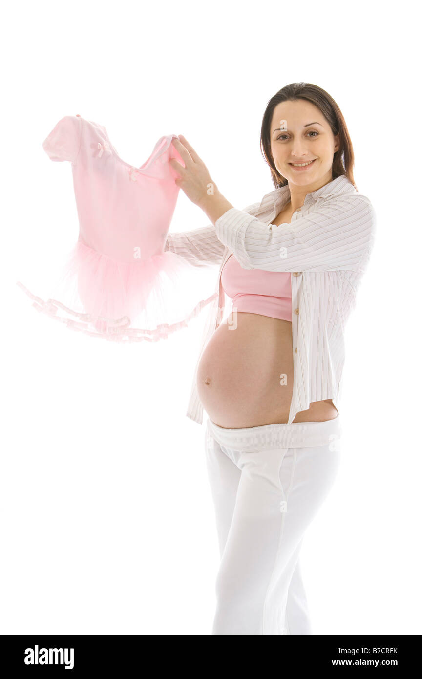 Pregnant woman holding up a pink tutu smiling Stock Photo