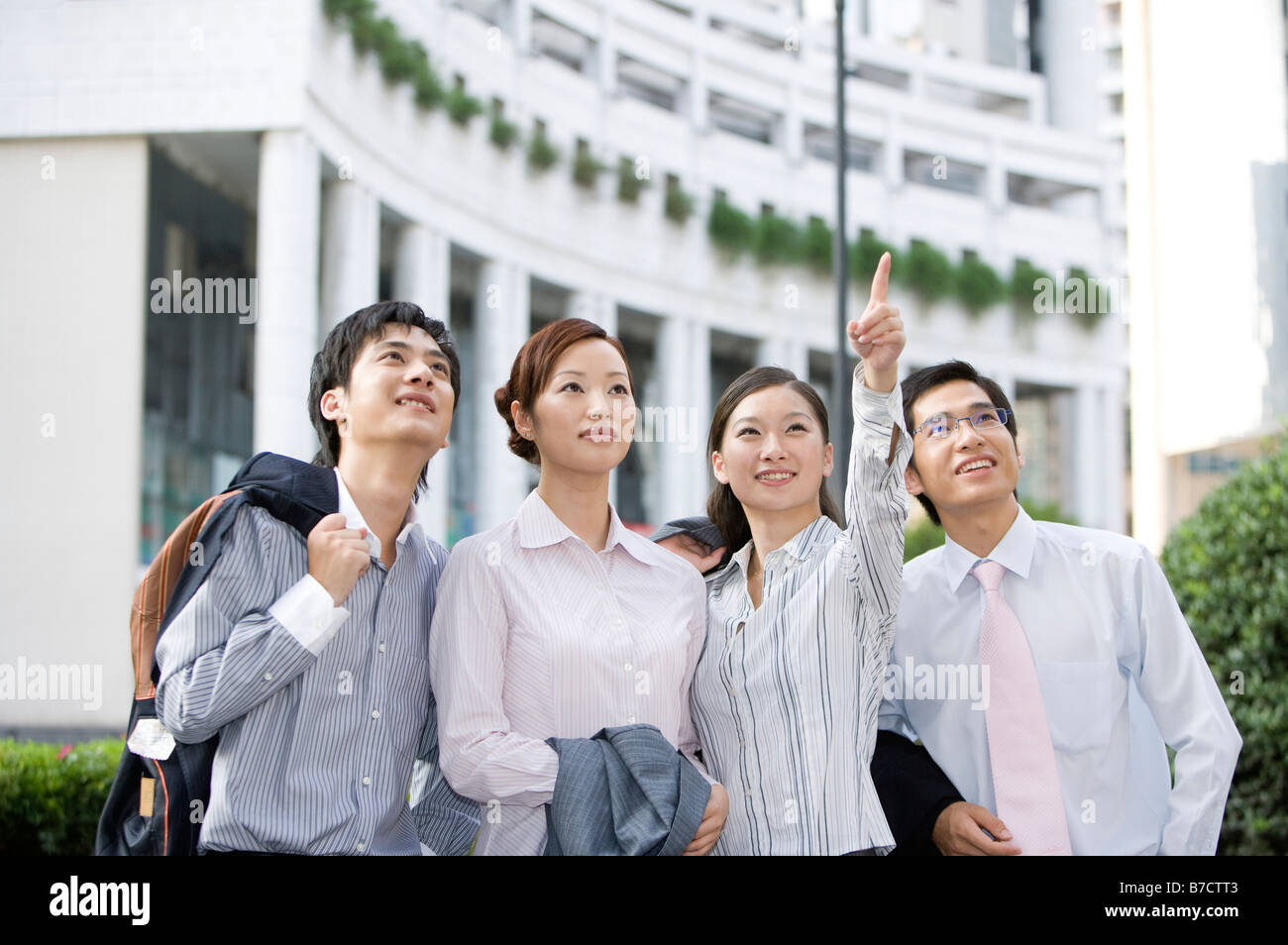 Four business people standing in a row and looking up Stock Photo - Alamy