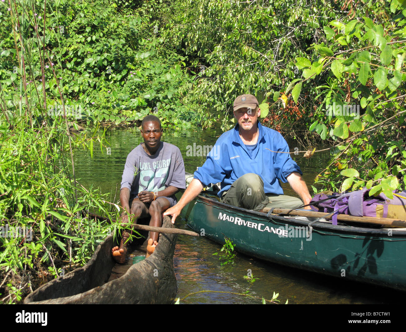 Phil Harwood with his Congolese fisherman guide on route through jungle channels on Luapula River Democratic Republic of Congo Stock Photo