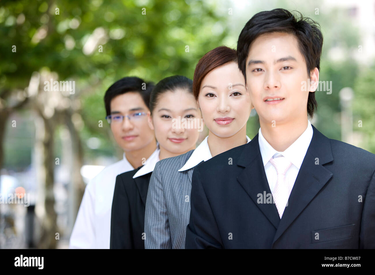Four business people standing in a row and looking at the camera Stock ...