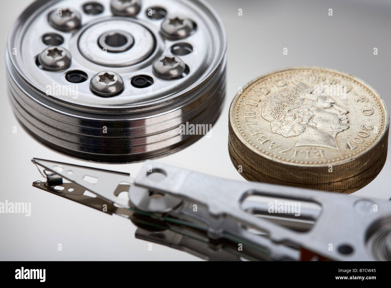 uk british pound coin sitting on the disc of an opened computer hard drive Stock Photo