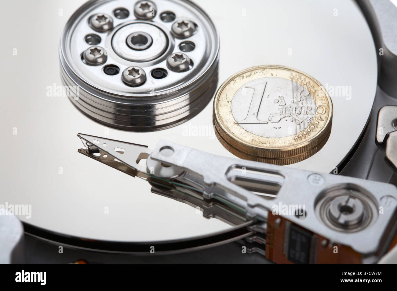 one euro coin sitting on the platter of an open computer hard drive Stock Photo