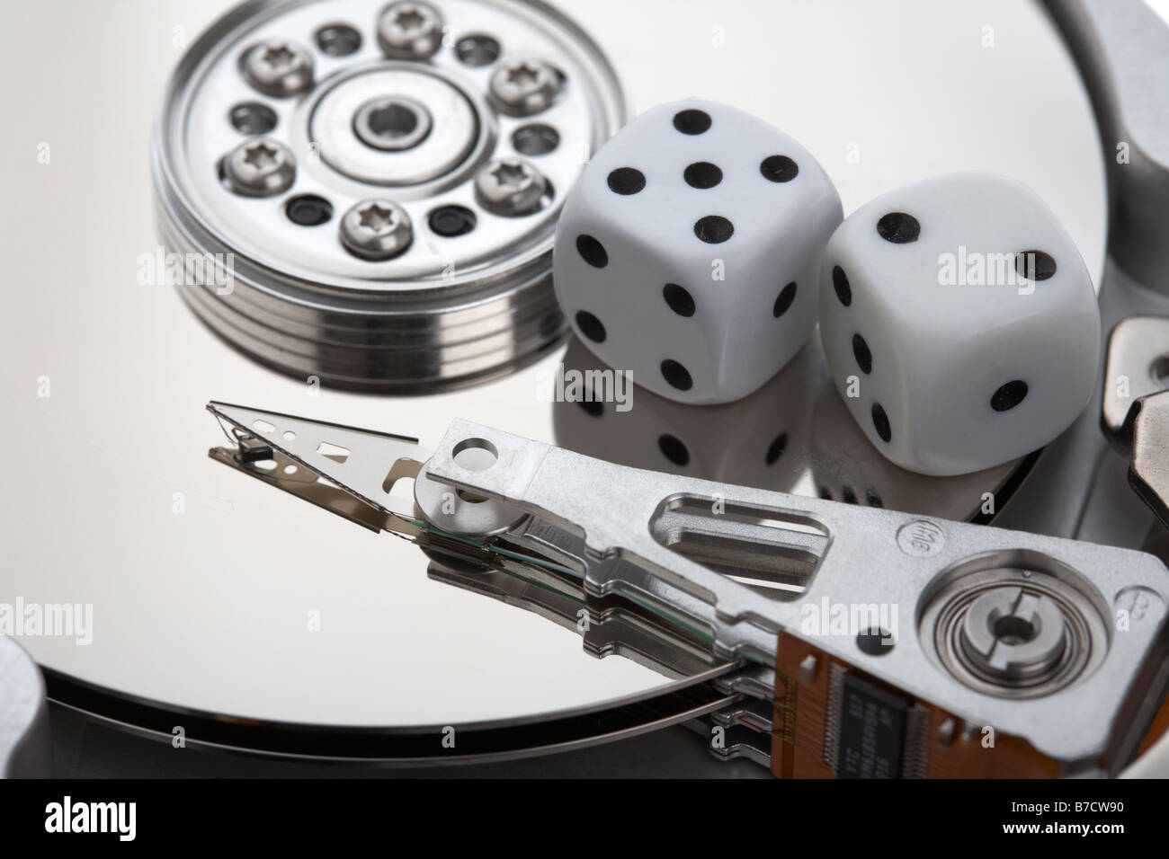 pair of dice sitting on the open platter of a computer hard drive Stock Photo