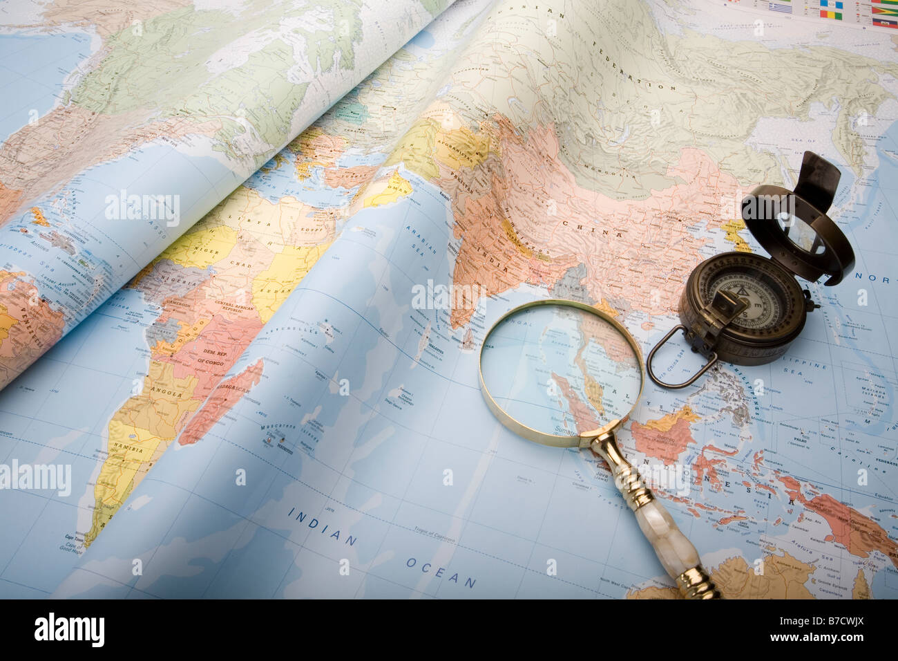 A world map with old world war ll compass and magnifying glass Stock Photo