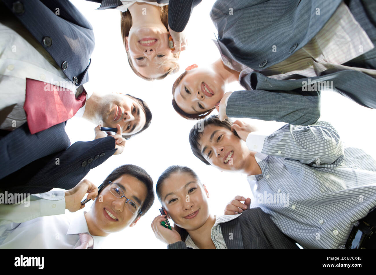 Six business people looking at the camera holding the mobile phones Stock Photo