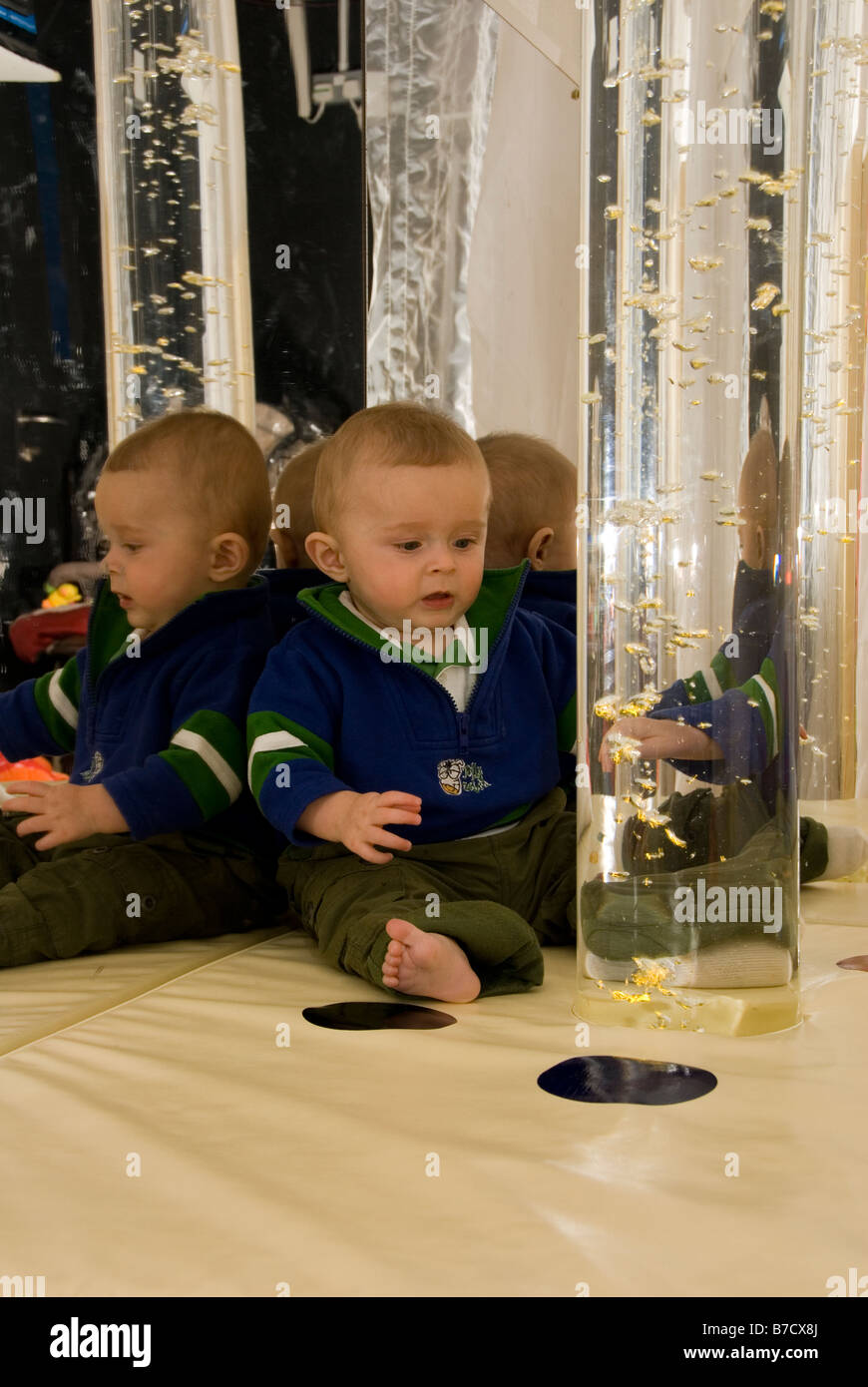 Baby Boy Looking at Coloured Bubbles Rising Up Inside Glass Tube in